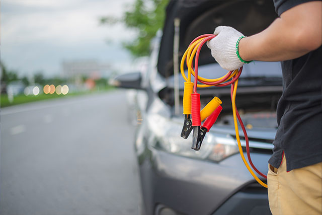 Auto erhält Starthilfe über Überbrückungskabel – leere Batterie starten.