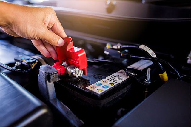 Autobatterie wird ausgebaut – Schritt beim Batteriewechsel im Motorraum.
